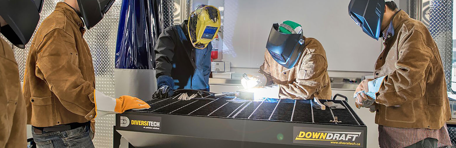 Mohawk College welding students learning how to work safely with a downdraft table for proper air filtration.